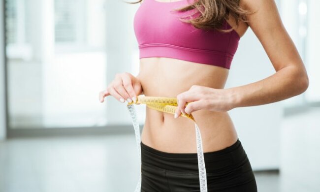 devushka-meryaet-santimetrom-taliyu-700×467