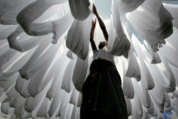 A dye factory worker suns fabric after washing them in Narayanganj near Dhaka, Bangladesh, December 25, 2016. REUTERS/Mohammad Ponir Hossain