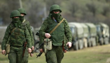 Armed men, believed to be Russian servicemen, march outside Ukrainian military base in Perevalnoye