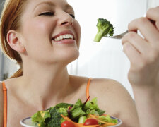 Young woman eating salad, head and shoulders
