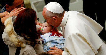 Pope Francis kisses a baby at the end of a special audience for Italy quake victims in Paul VI Hall 