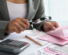 Businesswoman checking bills using magnifying glass