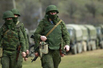 Armed men, believed to be Russian servicemen, march outside Ukrainian military base in Perevalnoye