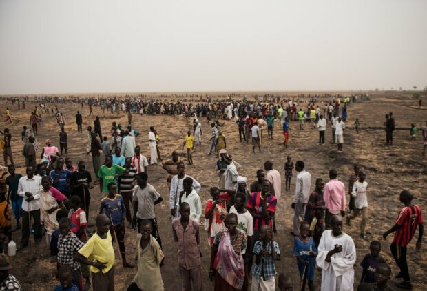 Tens of thousands of South Sudanese people line up for the first food distribution administered by the International Committee of the Red Cross since the fighting stopped in Leer and a tentative peace is holding in Unity State, South Sudan, March 17, 2016. When fighting raged throughout Leer in 2014 and 2015, most of the population fled, leaving civilians unable to harvest crops,and many struggling to find food. The city of Leer, once a bustling city and headquarters of opposition leader Riek Marchar, is now a ghost town reduced to rubble and the carcases of buildings. (Credit: Lynsey Addario for Time Magazine)