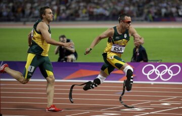 South Africa's Oscar Pistorius takes the baton from teammate L J van Zyl during the men's 4x400-meter during the athletics in the Olympic Stadium at the 2012 Summer Olympics, London, Friday, Aug. 10, 2012. (AP Photo/Matt Slocum)