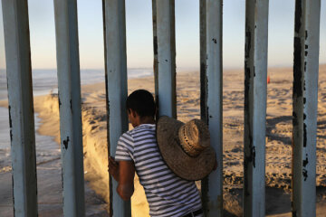 TIJUANA, MEXICO - SEPTEMBER 25: A man looks through the U.S.-Mexico border fence into the United States on September 25, 2016 in Tijuana, Mexico. Friendship Park on the border is one of the few places on the 2,000-mile border where separated families are allowed to meet. (Photo by John Moore/Getty Images)