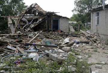Разрушенный жилой дом после утреннего обстрела боевиков в селе Луганское Донецкой области, 23 июля 2