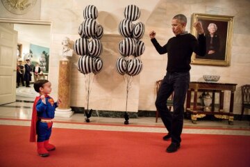обама надувает бицепсы перед мальчиком во время праздника Хэлоуин в Белом Доме