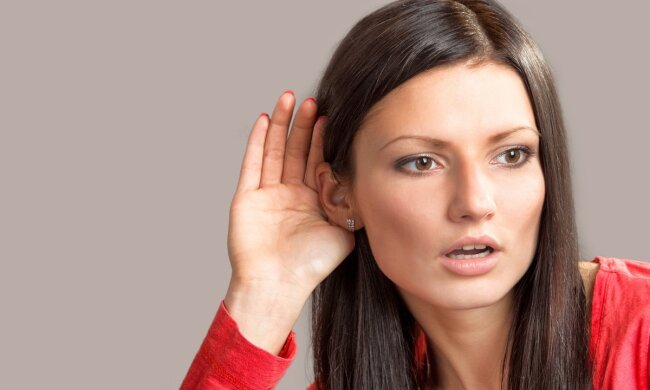 Portrait of a listening girl on gray background