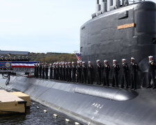 Crew members stand on the topside of the submarine during the commissioning of the USS Illinois, the