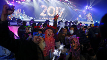 People pose for pictures as they attend a New Year's Eve countdown event in Beijing, China, December 31, 2016.  REUTERS/Thomas Peter