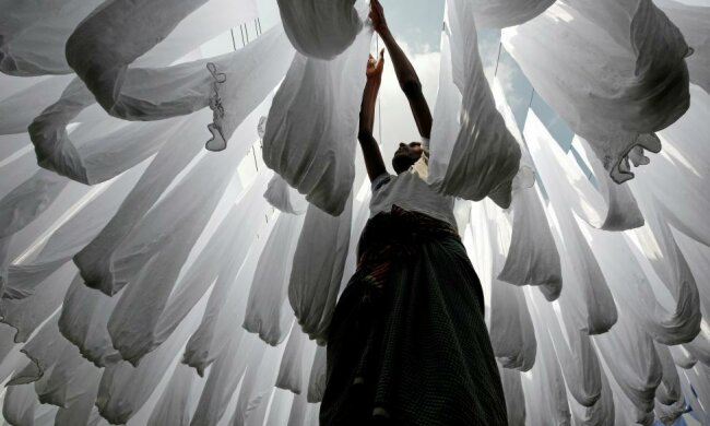 A dye factory worker suns fabric after washing them in Narayanganj near Dhaka, Bangladesh, December 25, 2016. REUTERS/Mohammad Ponir Hossain