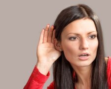 Portrait of a listening girl on gray background
