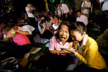 People weep after an announcement that Thailand’s King Bhumibol Adulyadej has died, at the Sir