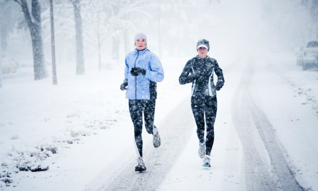 Two women run down Mountain Avenue in a snowstorm.