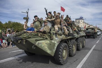 Pro-Russian rebels ride on an APC during a parade in Luhanks, eastern Ukraine