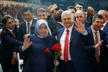 Turkey's Transportation Minister Binali Yildirim, accompanied by his wife Semiha Yildirim, greets members of his party as he arrives for the Extraordinary Congress of the ruling AK Party (AKP) to choose the new leader of the party, in Ankara, Turkey May 22, 2016. REUTERS/Umit Bektas