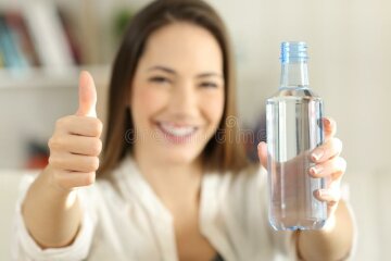 женщина-показывая-бутылку-воды-с-большими-пальцами-руки-вверх-109159636