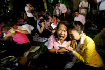 People weep after an announcement that Thailand’s King Bhumibol Adulyadej has died, at the Sir