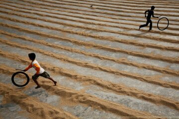 Children play with bicycle tires at a rice-processing mill in Muktarpur, on the outskirt of Dhaka, Bangladesh, December 29, 2016. REUTERS/ Mohammad Ponir Hossain
