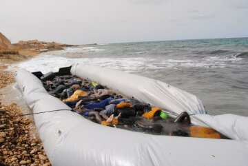 Тела погибших мигрантов в надувной лодке на побережье в городе Эз-Завия в Ливии, 20 февраля 2017 года.