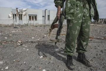 A pro-Russian rebel holds his rifle at the destroyed airport in Luhanks, eastern Ukraine