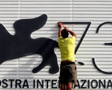 A worker sets a sign before the 73rd Venice Film Festival in Venice