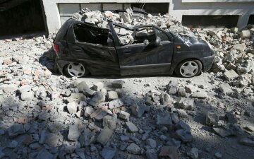 A destroyed car is seen following an earthquake in Amatrice