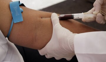 A nurse takes blood for a free HIV test, during an HIV/AIDS awareness rally on World AIDS Day in San