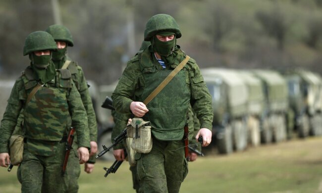 Armed men, believed to be Russian servicemen, march outside Ukrainian military base in Perevalnoye