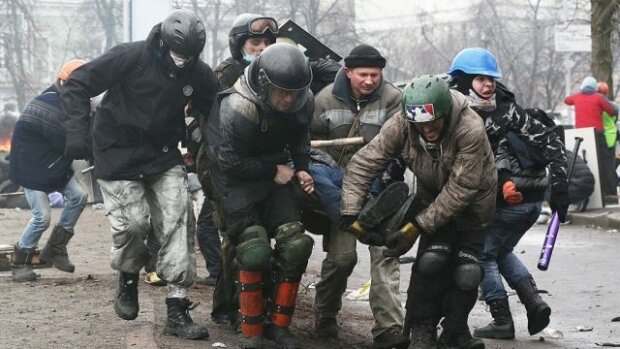 Виносять пораненого майданівця Андрій Грицай. Крайній зліва в сірих штанах і чорній куртці Богдан Кл