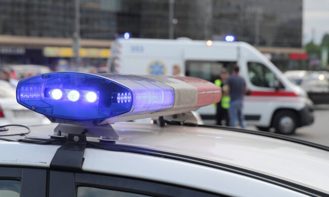 Blue light flasher atop of a police car. City lights on the background.