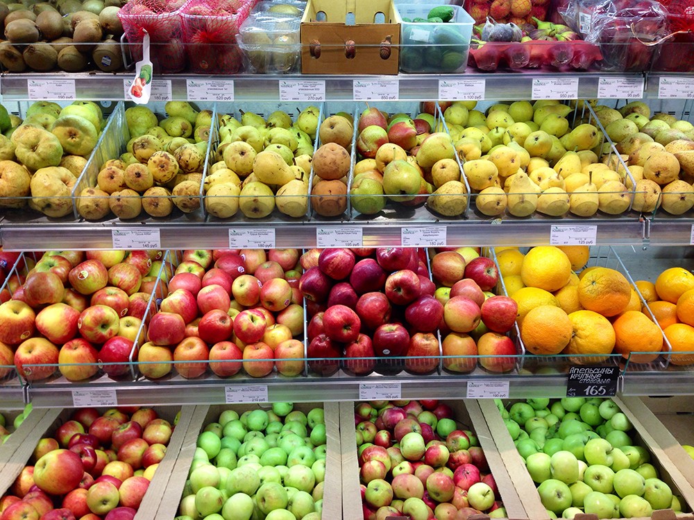На прилавках магазинов лежат отборные овощи. Прилавок с фруктами. Фрукты в магазине. Прилавок с овощами и фруктами. Ассортимент фруктов.